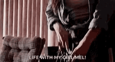 a woman is sitting on a couch with her legs crossed and the words `` life with my caramel '' written on the screen .