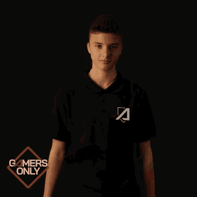 a young man applauds in front of a gamers only sign