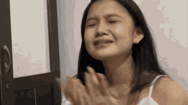 a woman is crying with a tear coming out of her eyes .