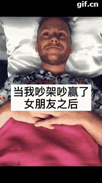 a man laying on a bed with a sign that says gif.cn above him