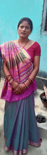 a woman wearing a pink top and a blue skirt stands in front of a blue wall