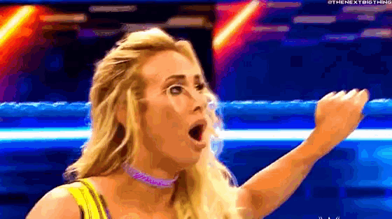 a woman is making a surprised face in a wrestling ring .