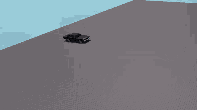 a black car is driving on a gray brick road