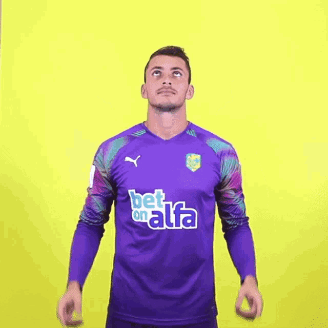 a man wearing a purple jersey with the word alfa on it