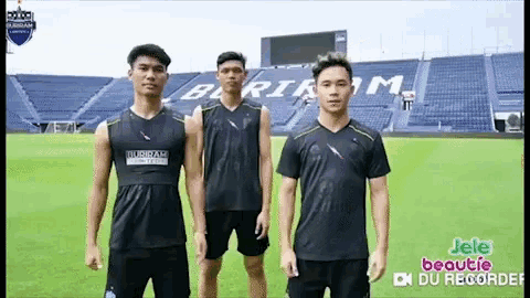 a group of young men standing on a soccer field .