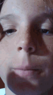 a close up of a person 's face with a red spot on their nose