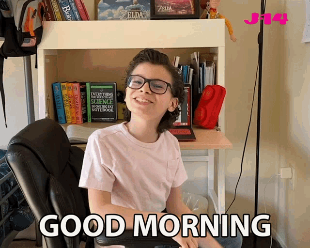 a young boy sitting at a desk with the words good morning written on the bottom