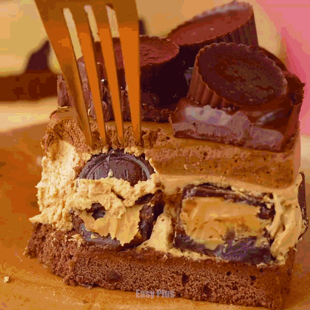 a piece of cake with peanut butter cups on top is being eaten with a fork