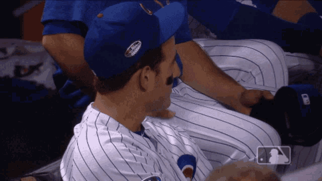 a baseball player wearing a blue hat with a patch that says chicago cubs