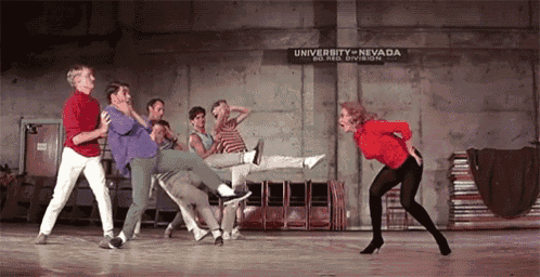 a group of people are dancing in front of a sign for university of nevada