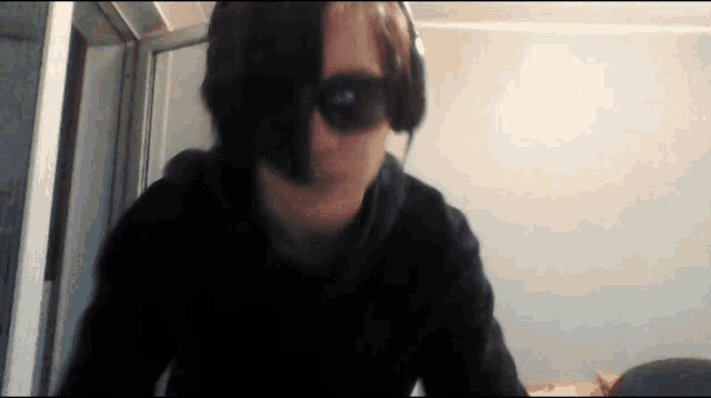 a man wearing sunglasses and headphones is looking at the camera
