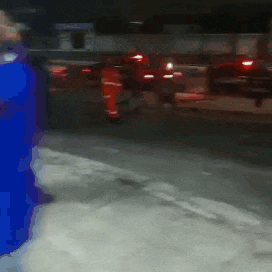 a blurry picture of a person in a blue jacket walking down a street at night