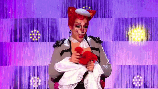 a woman in a fox costume is holding a red heart in her hands .