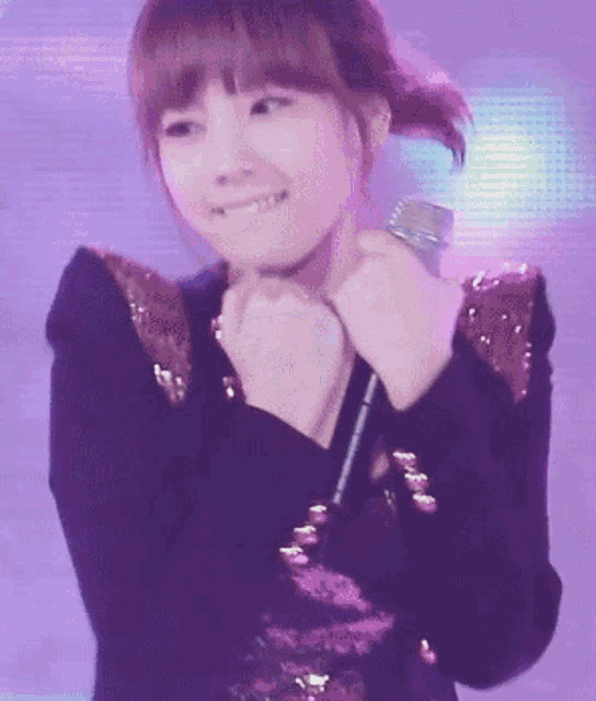 a girl is holding a microphone and smiling