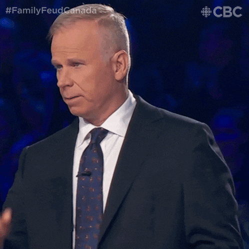 a man in a suit and tie is on a tv show called family feud canada ..