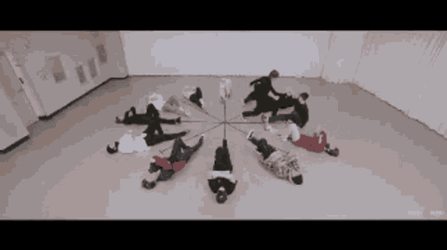 a group of people are laying in a circle in a room