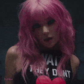 a woman with pink hair is wearing a black shirt that says you
