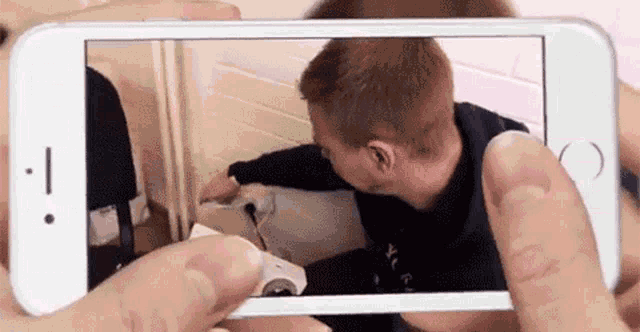 a person is taking a picture of a man with a cell phone