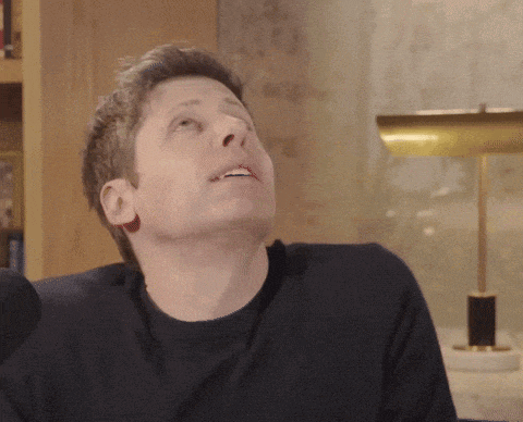 a man in a black sweater looks up at something