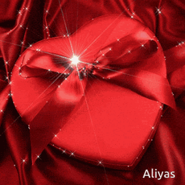 a red heart with a red ribbon and the name aliyas on the bottom right