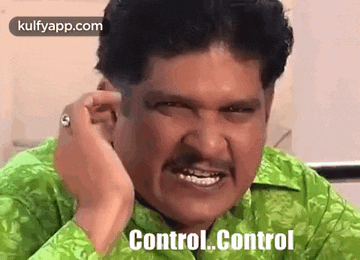 a man in a green shirt is making a funny face and says `` control control '' .