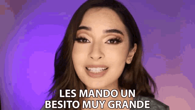 a woman with braces on her teeth is smiling and says les mando un besito muy grande