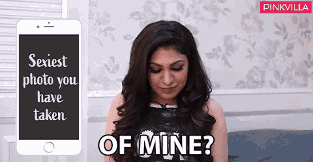 a woman is sitting in front of a cell phone that says " sexiest photo you have taken of mine "