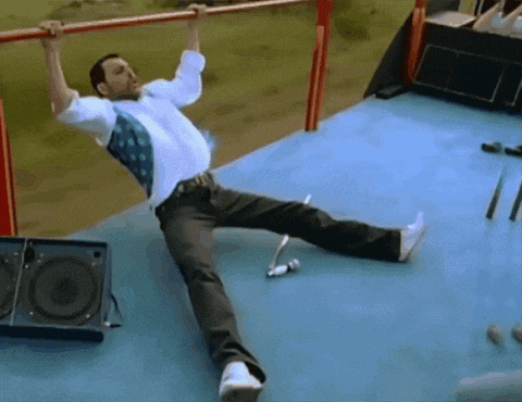 a man hangs upside down on a bar while laying on the floor
