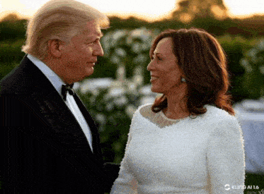 a man in a tuxedo and a woman in a white dress look into each other 's eyes