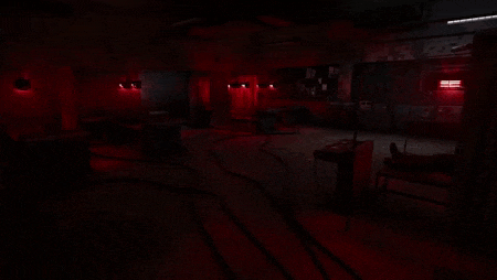 a dark room with red lights on the walls and ceiling .