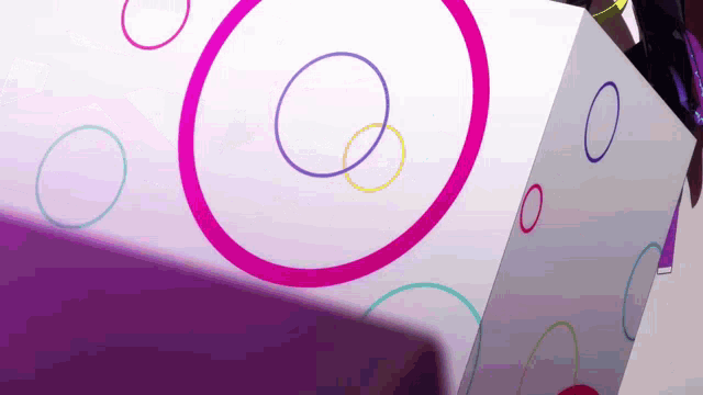 a cube with circles on it and a person standing in front of it