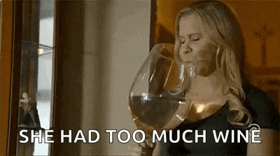 a woman is drinking from a very large wine glass .