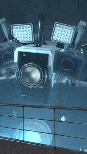 a camera with a blue light coming out of it is behind a railing