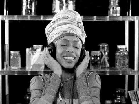 a woman wearing a turban is listening to music through headphones .