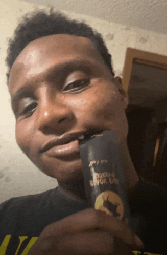 a man is holding a can that says ' black cat ' on it