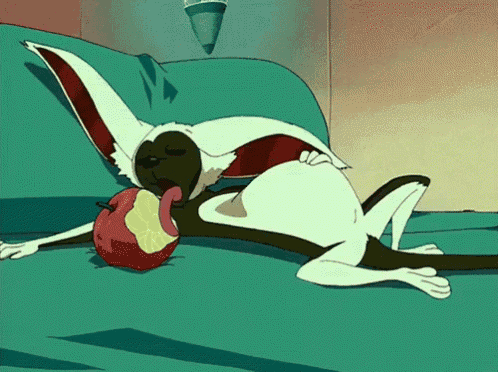 a cartoon rabbit is laying on a couch with an apple in its mouth