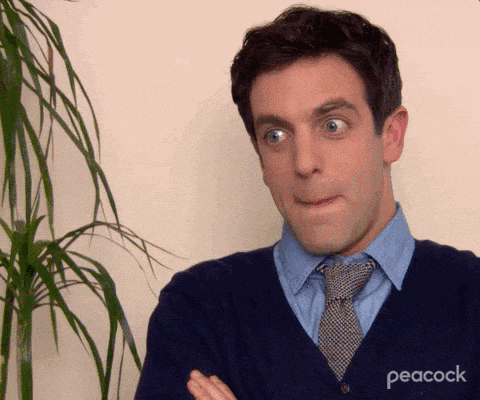 a man wearing a peacock sweater makes a face