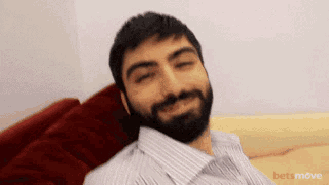 a man with a beard is sitting on a couch with bet move written on the bottom