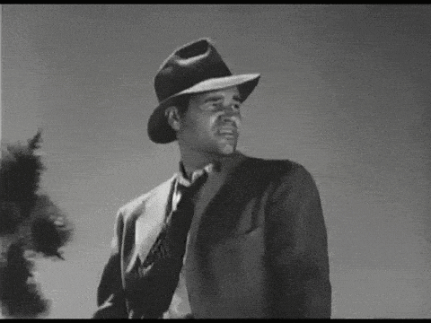 a black and white photo of a man wearing a hat and tie .