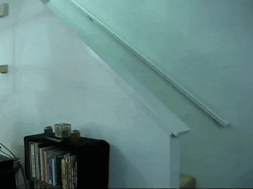 a staircase with a bookshelf underneath it and a white railing