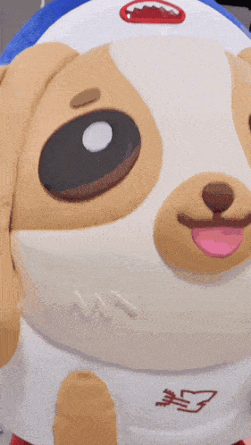 a stuffed animal that looks like a dog with a blue hat on