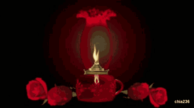 a red lamp with a candle inside of it is surrounded by roses