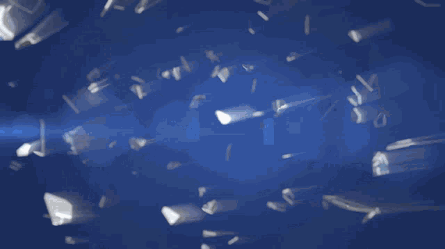 a blue background with a few pieces of glass floating in the air