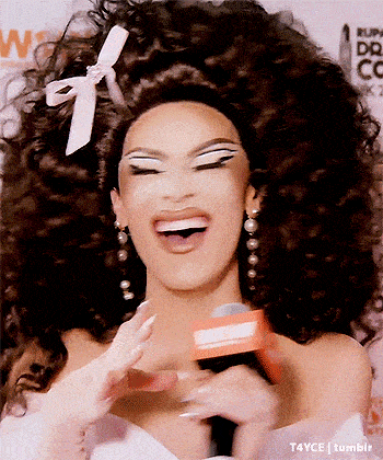 a woman in a wig is holding a microphone and smiling