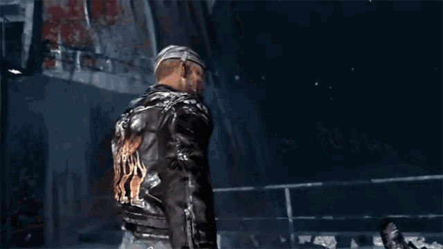 a man in a brown leather jacket is holding a sword