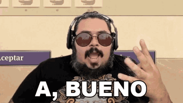 a man with a beard wearing headphones and sunglasses is making a funny face .