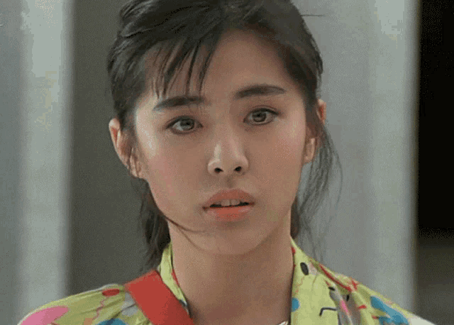 a close up of a woman 's face with a red strap around her shoulder