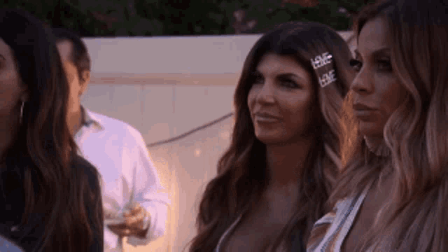 a group of women are standing next to each other and talking at a party .