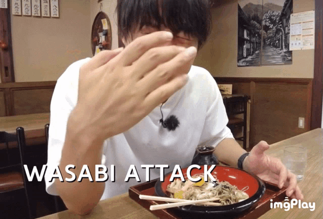 a man eating a bowl of food with the words " wasabi attack " on the bottom