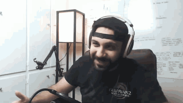 a man wearing headphones and a shirt that says guild wars 2